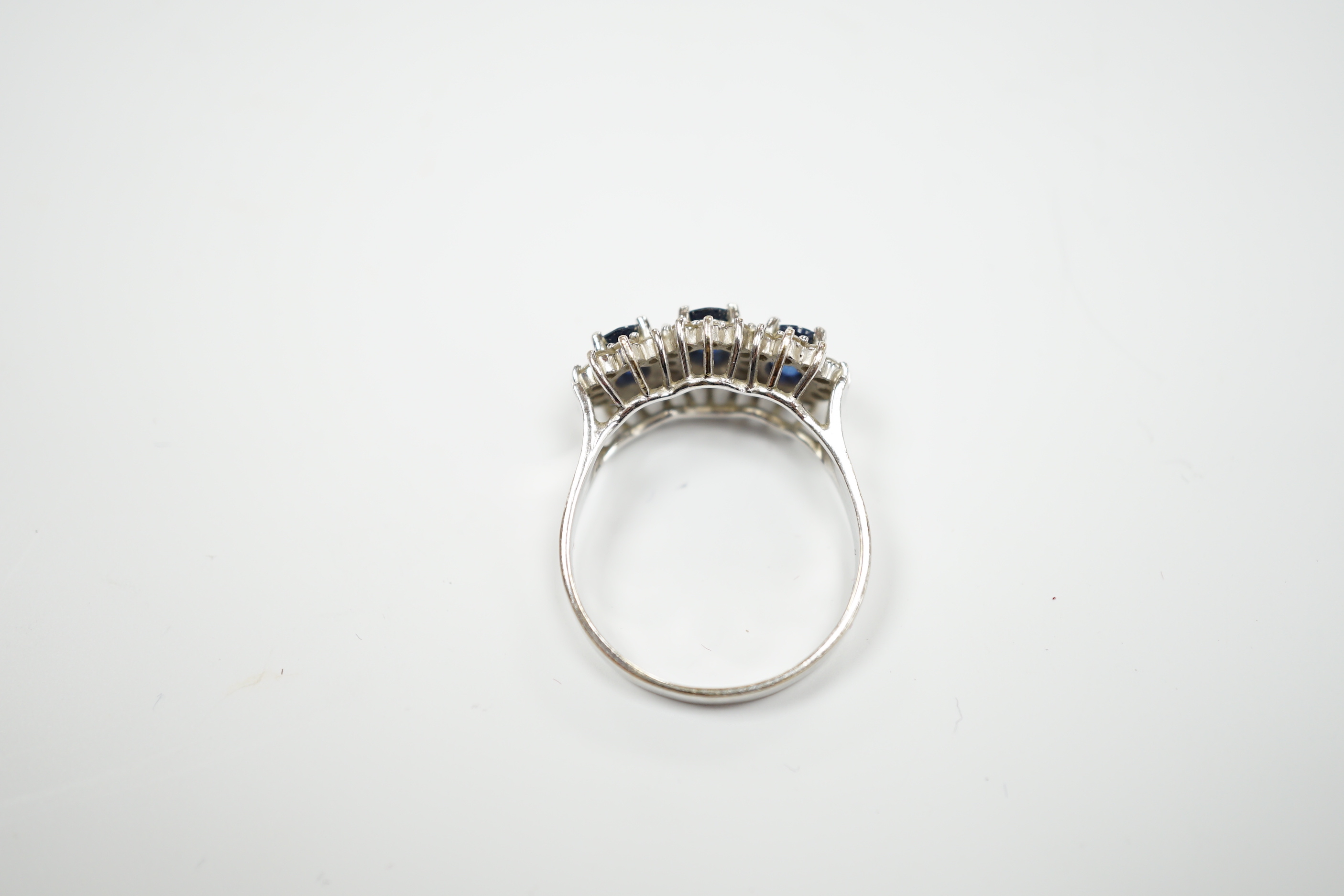 An 18k white metal, sapphire and diamond set triple cluster ring, size Q. gross weight 5.8 grams.